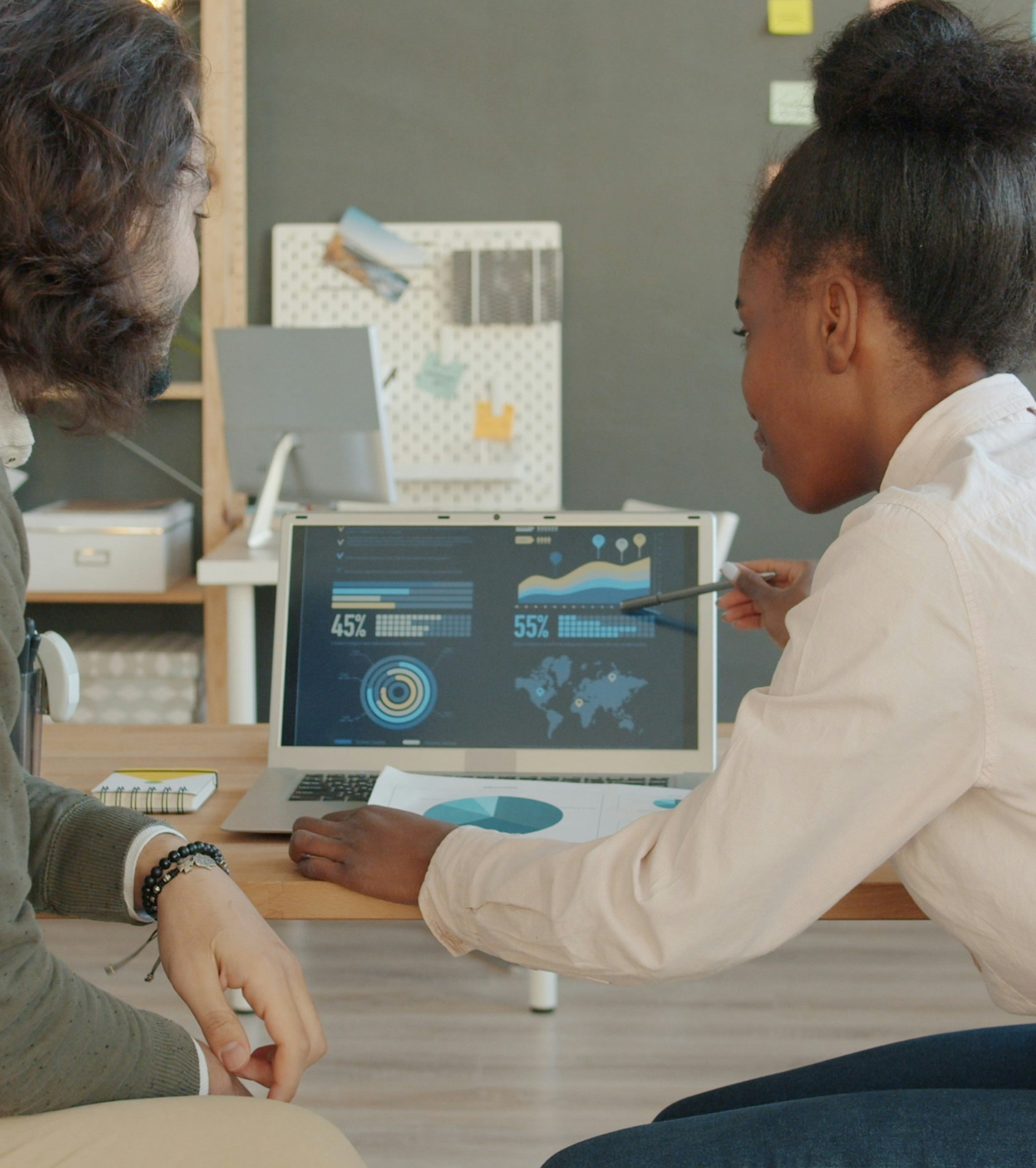 Two colleagues reviewing a data dashboard on a laptop