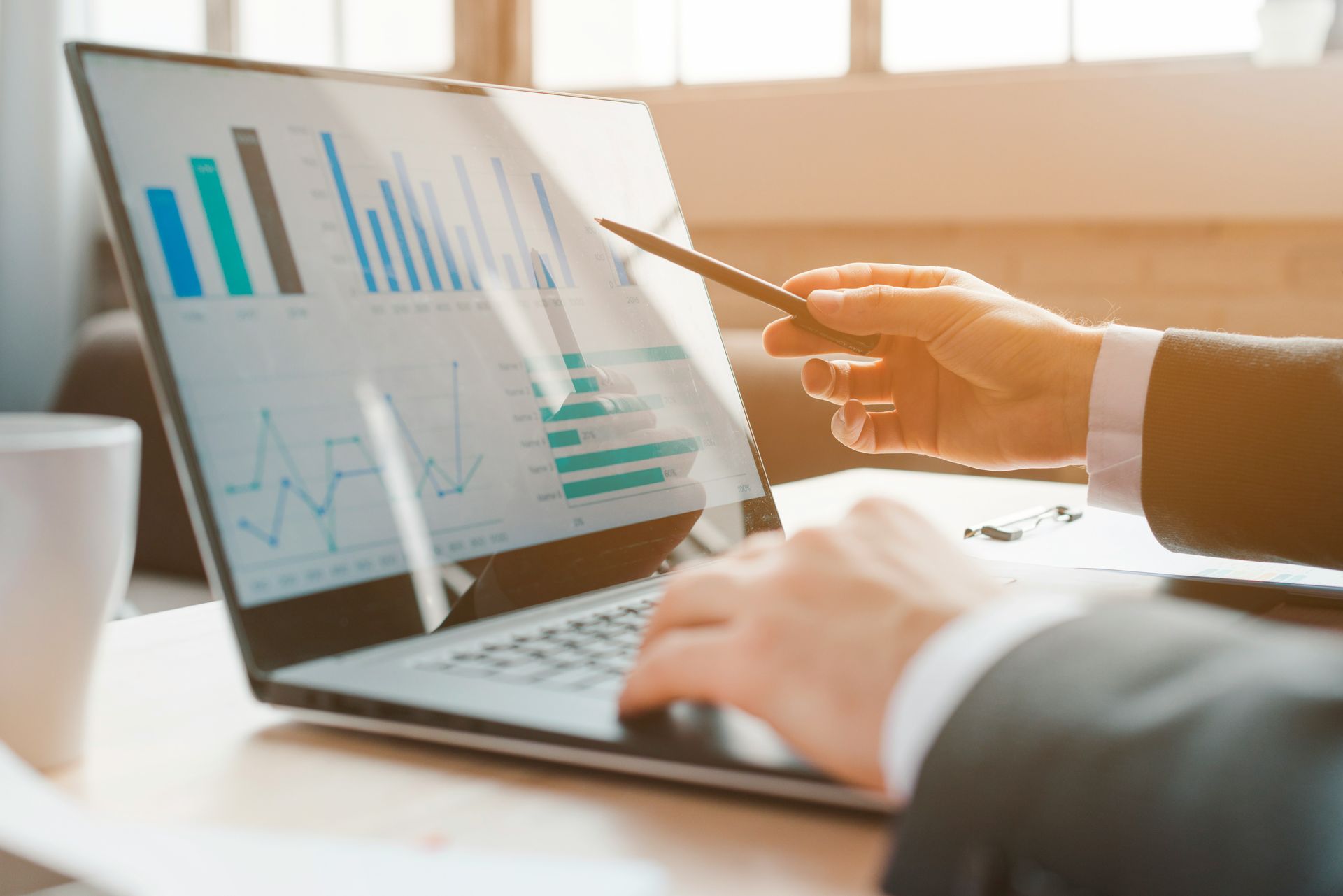 Consultant reviewing business performance charts on a laptop